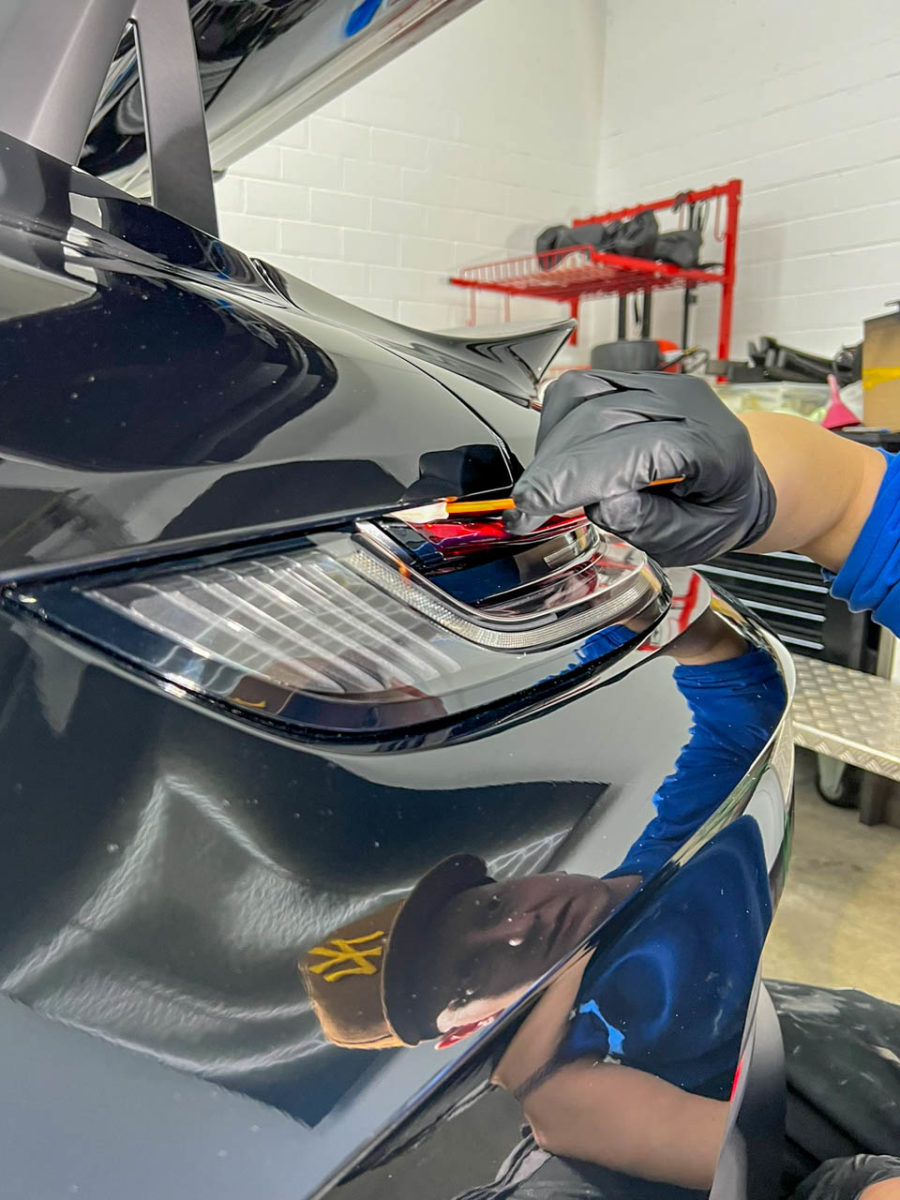 Die Keramikversiegelung wird per Wattestäbchen an der Heckleckte des Fahrzeugs aufgetragen und sorgt für einen Tiefenglanz - Sticker-Werk