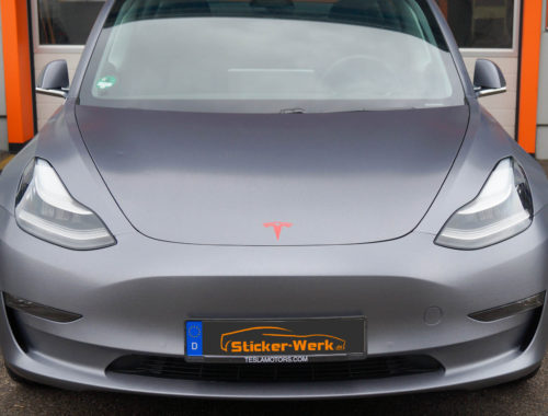 Tesla Model 3 Vollfolierung in Edelstahl gebürstet mit rotem Tesla Emblem Frontansicht - Sticker-Werk